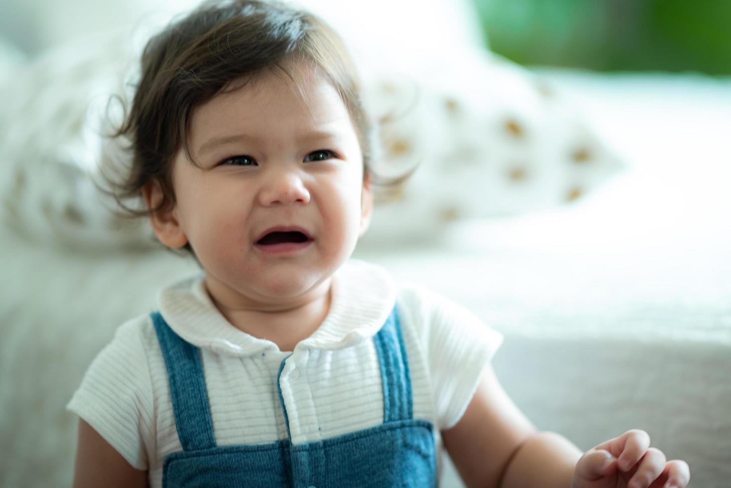 niño bebé personita está llorando en casa, recién nacido está llorando y viviendo en el interior de una casa con la familia, concepto de cuidado infantil y reconfortante foto