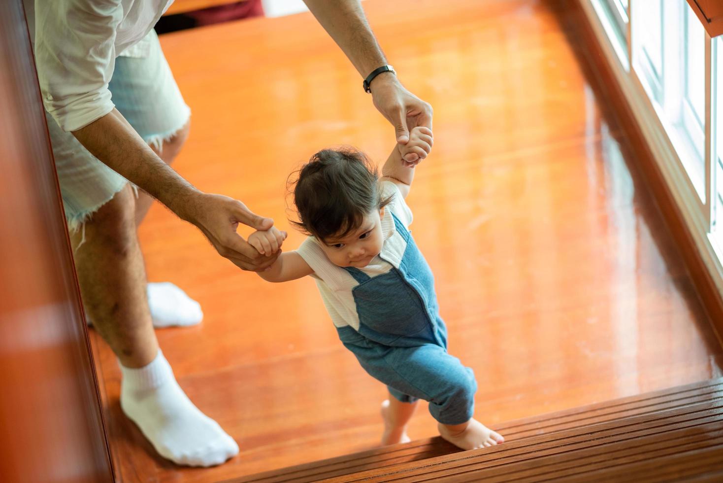 cute toddler little child family concept, baby learning to walk with father and mother to help care and holding hand, first step with childhood parent support, small love portrait little boy at home photo