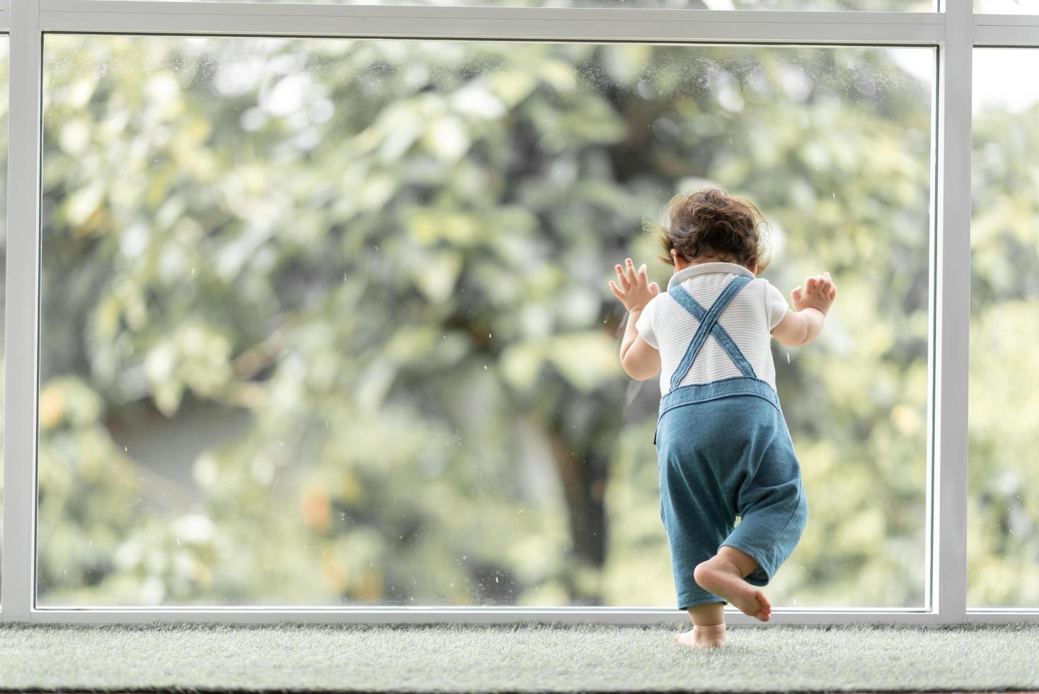 lindo concepto de familia de niño pequeño, bebé aprendiendo a caminar con el padre y la madre para ayudar a cuidar y tomar la mano, primer paso con el apoyo de los padres de la infancia, pequeño retrato de amor niño pequeño en casa foto