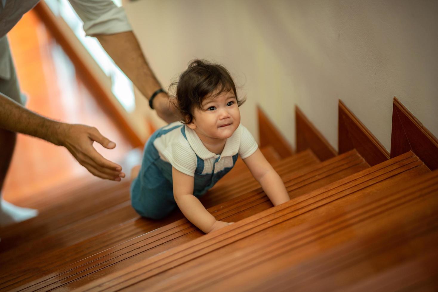 lindo concepto de familia de niño pequeño, bebé aprendiendo a caminar con el padre y la madre para ayudar a cuidar y tomar la mano, primer paso con el apoyo de los padres de la infancia, pequeño retrato de amor niño pequeño en casa foto