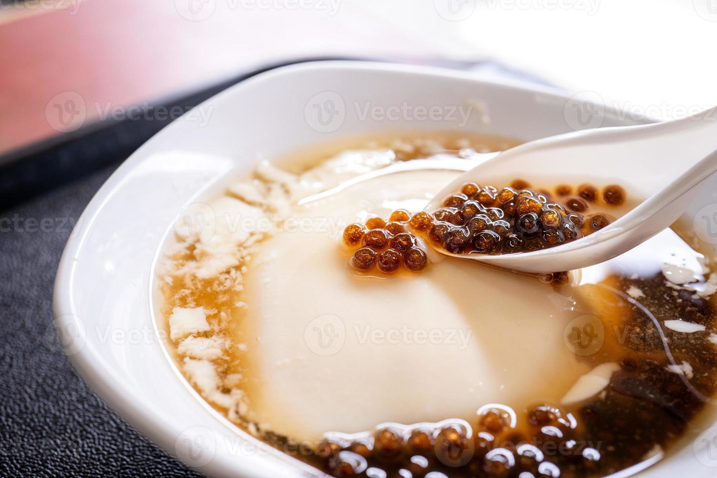 Popular Taiwan gourmet - Dessert of tapioca pearl ball bubble mixed bean curd tofu pudding douhua, dou hua in white bowl, close up, lifestyle photo