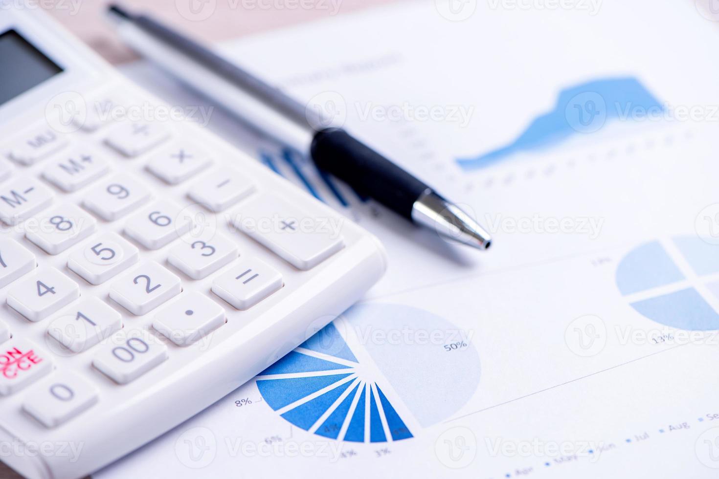 White calculator and report with chart and graph, concept of annual financial profit overview, banking and investment, copy space, macro, close up photo