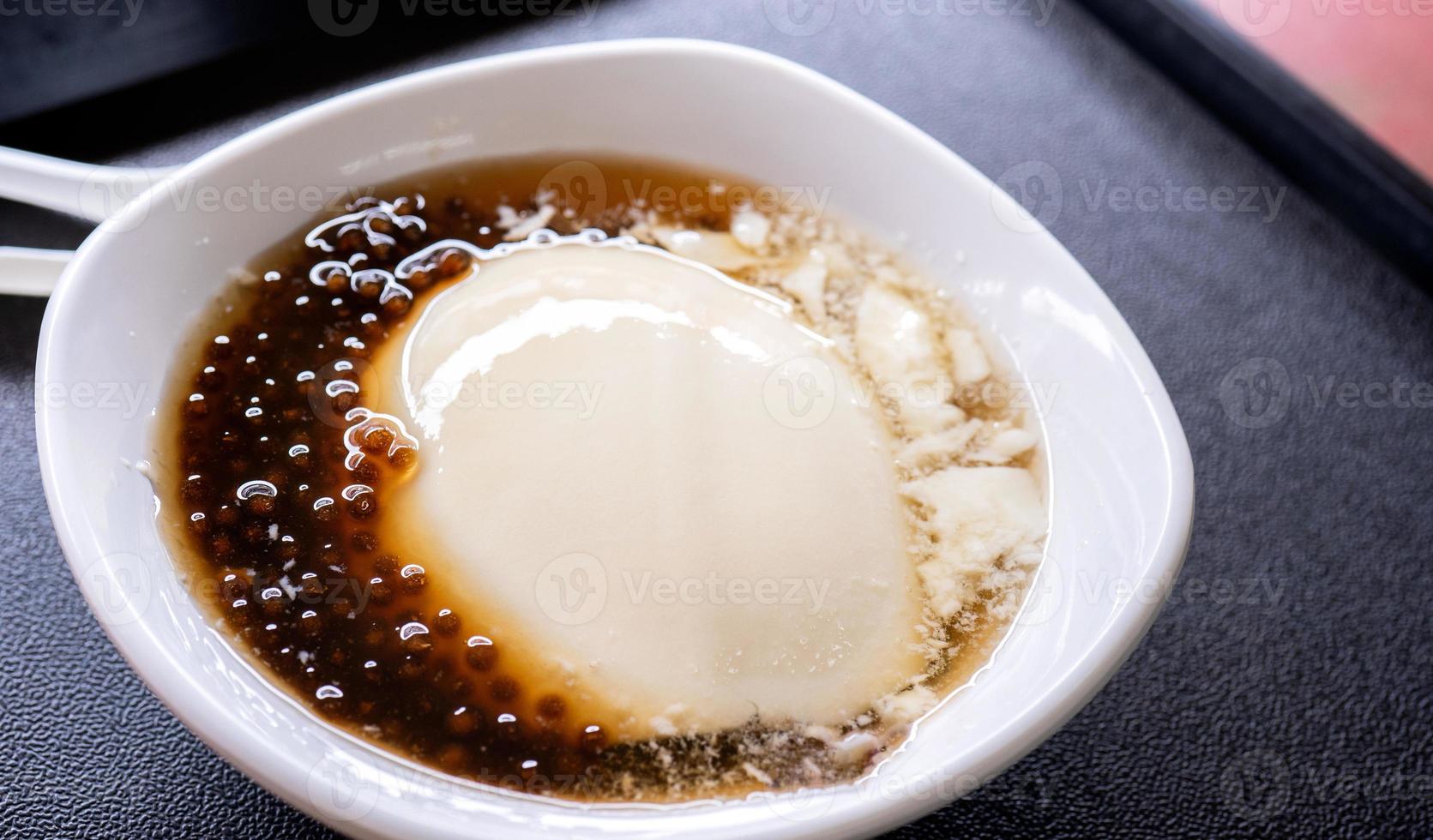 Popular Taiwan gourmet - Dessert of tapioca pearl ball bubble mixed bean curd tofu pudding douhua, dou hua in white bowl, close up, lifestyle photo