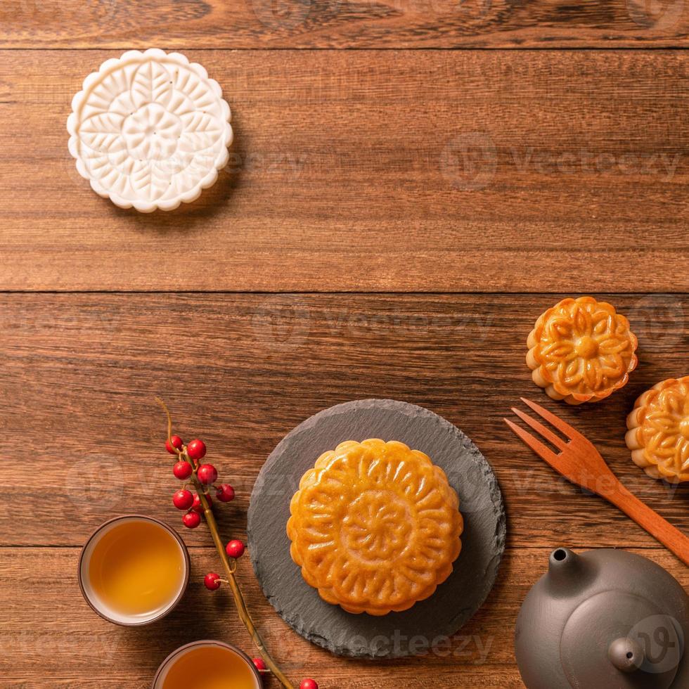 Creative Moon cake Mooncake table design - Chinese traditional pastry with tea cups on wooden background, Mid-Autumn Festival concept, top view, flat lay. photo