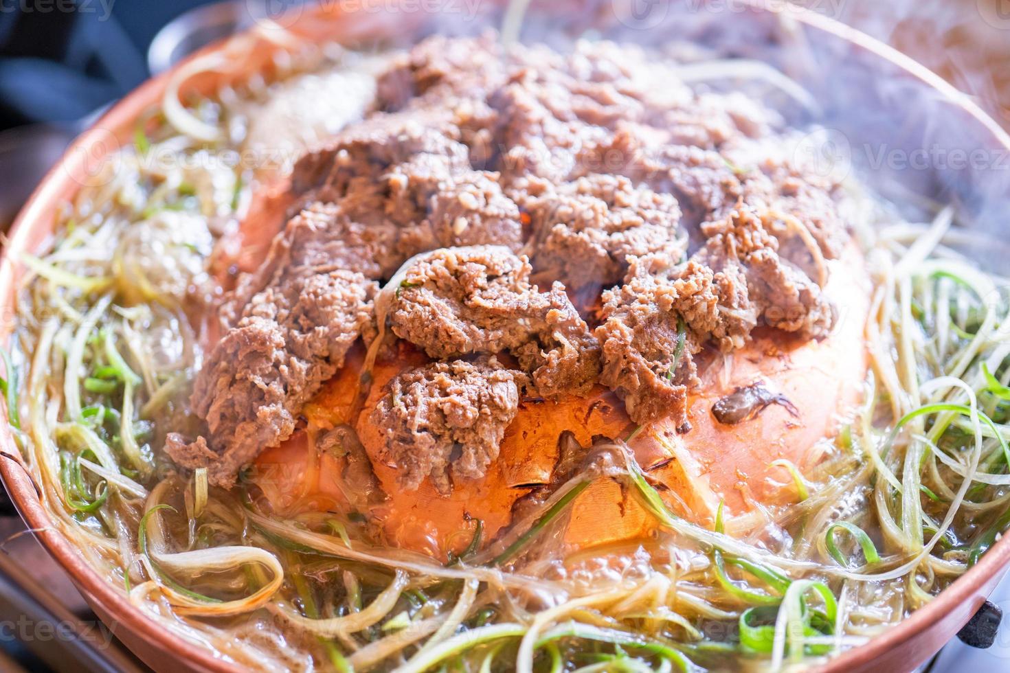 bulgogi de barbacoa de ternera en un restaurante coreano en seúl, estilo de vida cocina coreana fresca en una sartén de cobre con cebolla verde en rodajas, primer plano, espacio para copiar foto