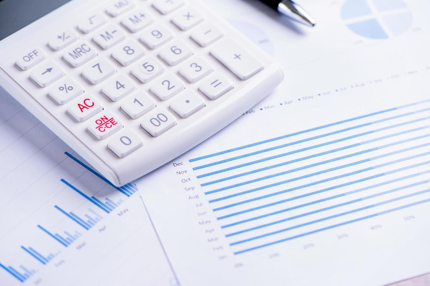 White calculator and report with chart and graph, concept of annual financial profit overview, banking and investment, copy space, macro, close up photo