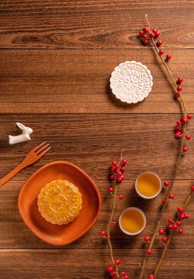 Creative Moon cake Mooncake table design - Chinese traditional pastry with tea cups on wooden background, Mid-Autumn Festival concept, top view, flat lay. photo