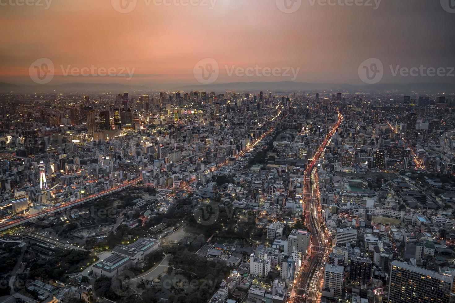 Panoramic Osaka cityscape in orange sky twilight time, with street, movement light, building and landmark. photo