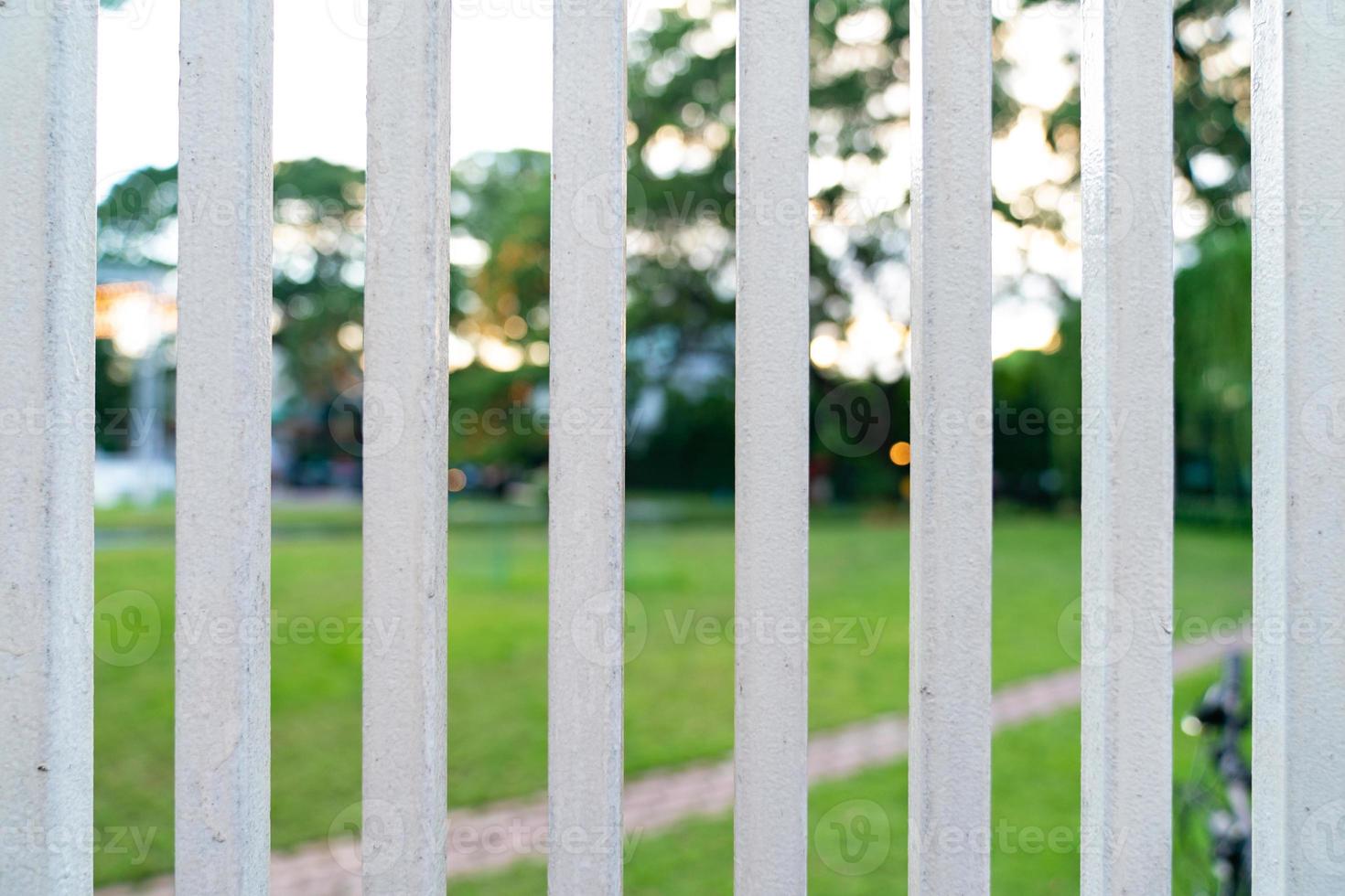 Vertical White Steel Fence Grille front of Garden. photo