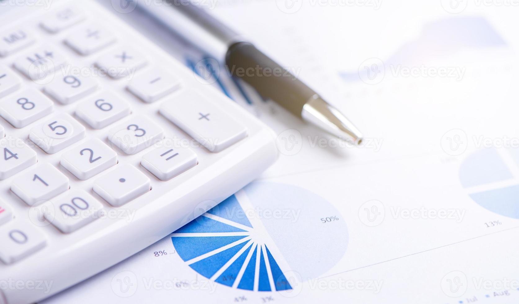 White calculator and report with chart and graph, concept of annual financial profit overview, banking and investment, copy space, macro, close up photo