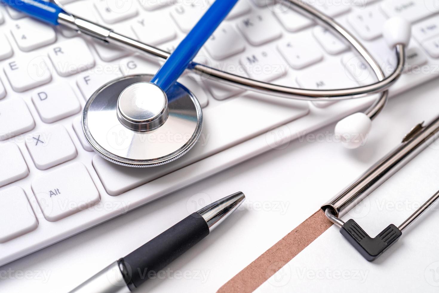 Stethoscope on computer keyboard on white background. Physician write medical case long term care treatment concept, close up, macro, copy space photo