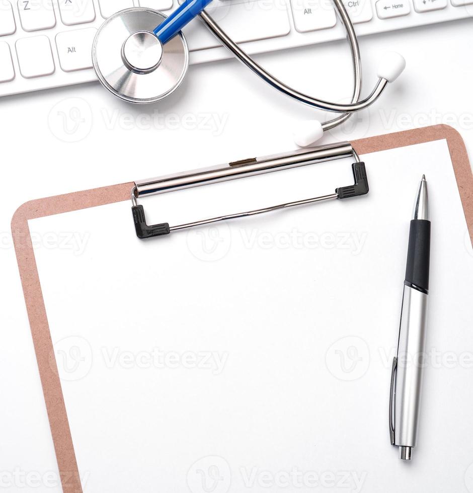 Medical Concept - Stethoscope on computer keyboard on white background. Physician long term care treatment concept. Top view, flat lay, copy space photo