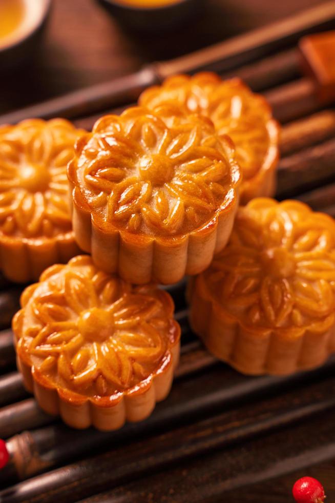 Moon cake Mooncake table setting - Round shaped Chinese traditional pastry with tea cups on wooden background, Mid-Autumn Festival concept, close up. photo