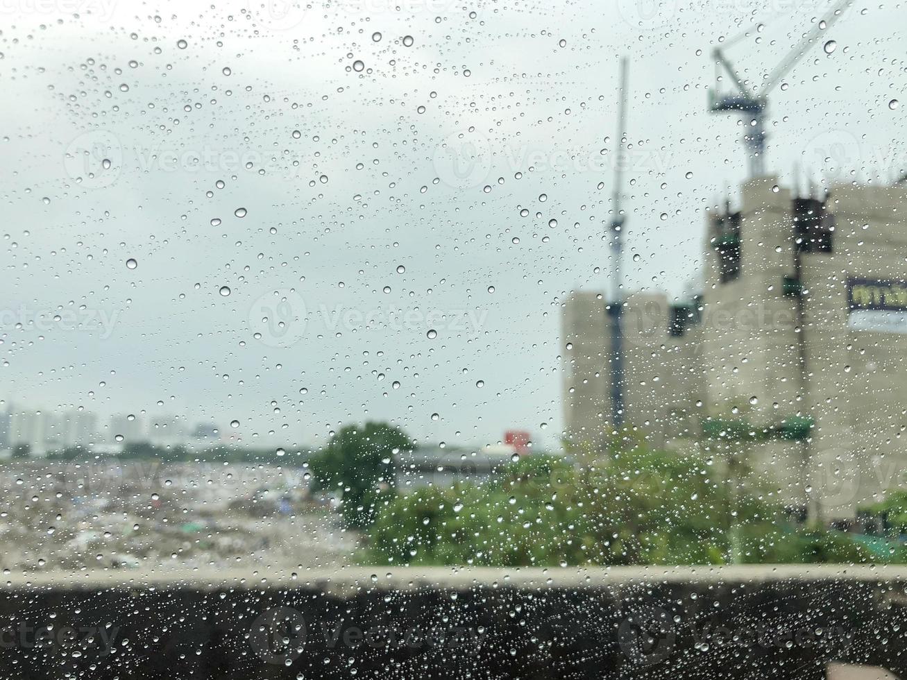 la lluvia en el coche espejo con el fondo del sitio de construcción. foto