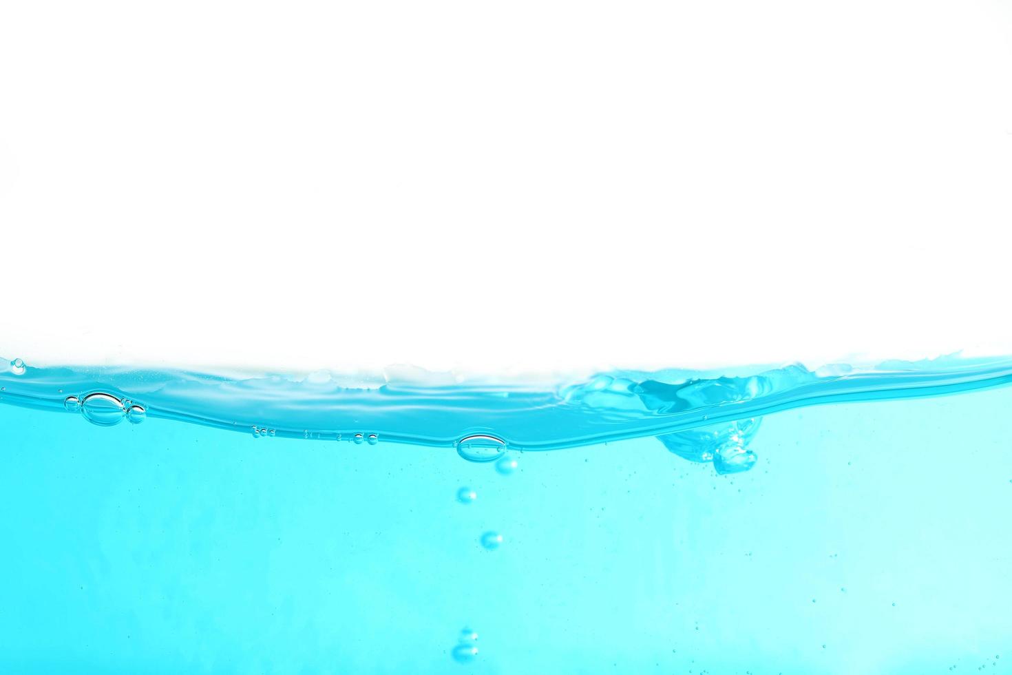 Agua superficial azul y burbuja de aire aislado sobre fondo blanco. foto