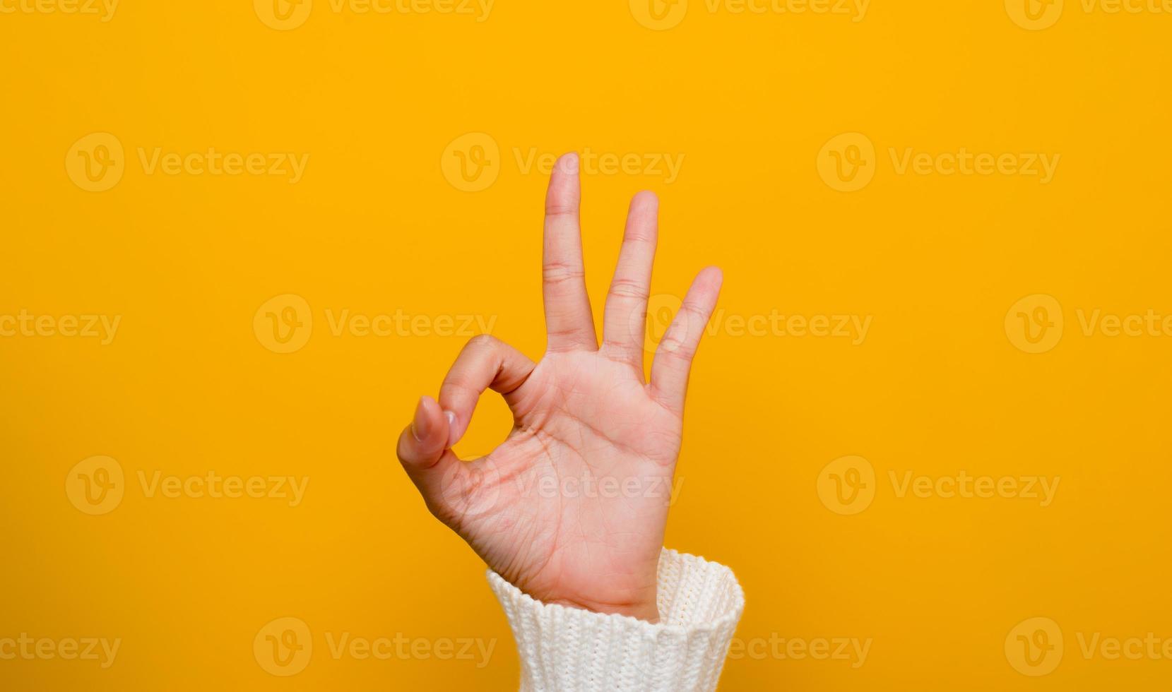 image of hands showing ok gesture on a yellow background photo