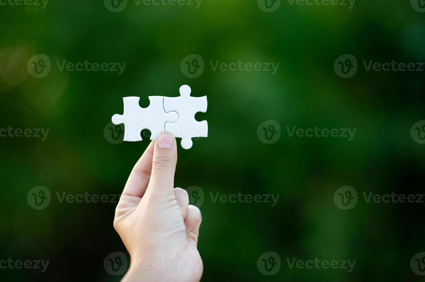 Hands and white jigsaw puzzles Close-up image and integration Business concept and unity photo
