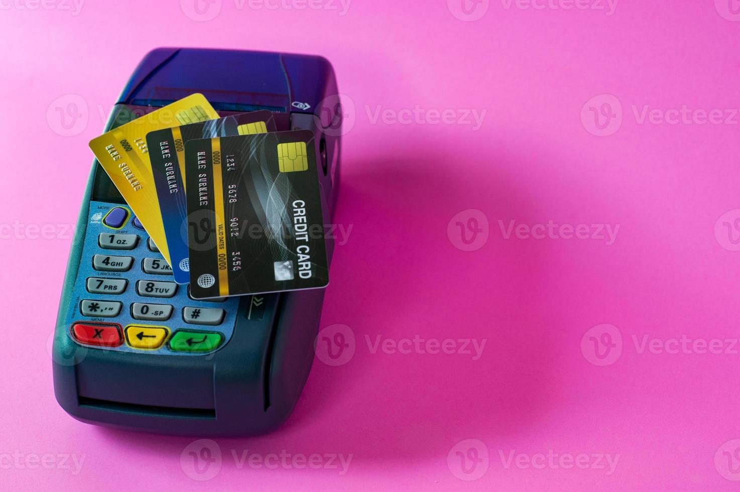 Credit card and credit card scanner on a pink background photo