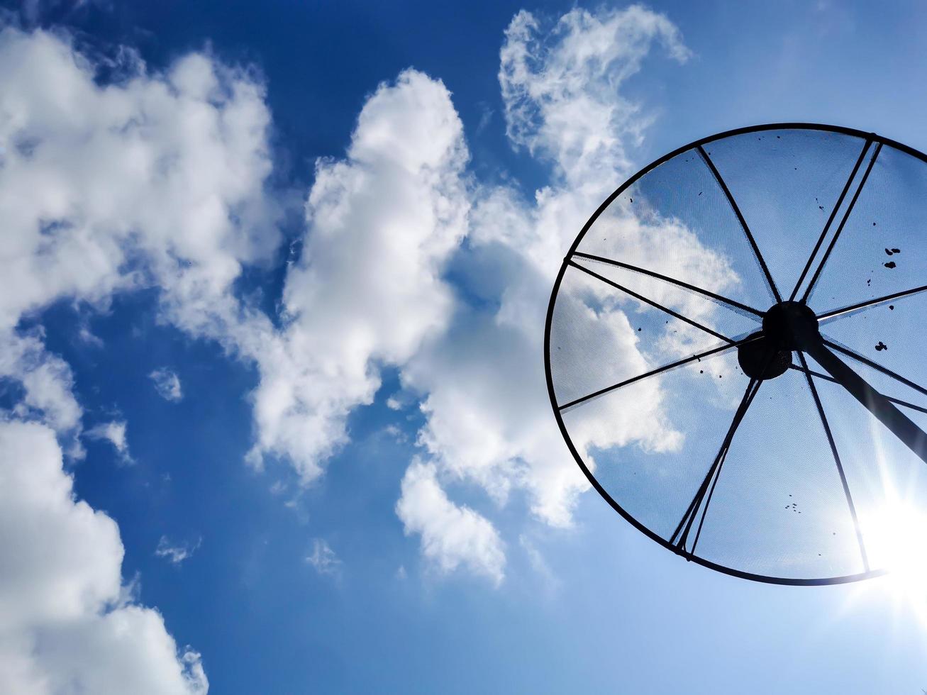 una imagen de un cielo nublado durante el día y una antena parabólica de televisión en casa. foto