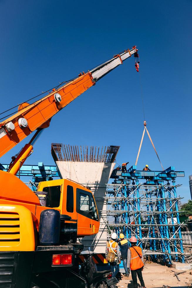 Industrial Crane lifting steel frame in construction site. Bandung, INDONESIA-MARCH 17, 2022 photo