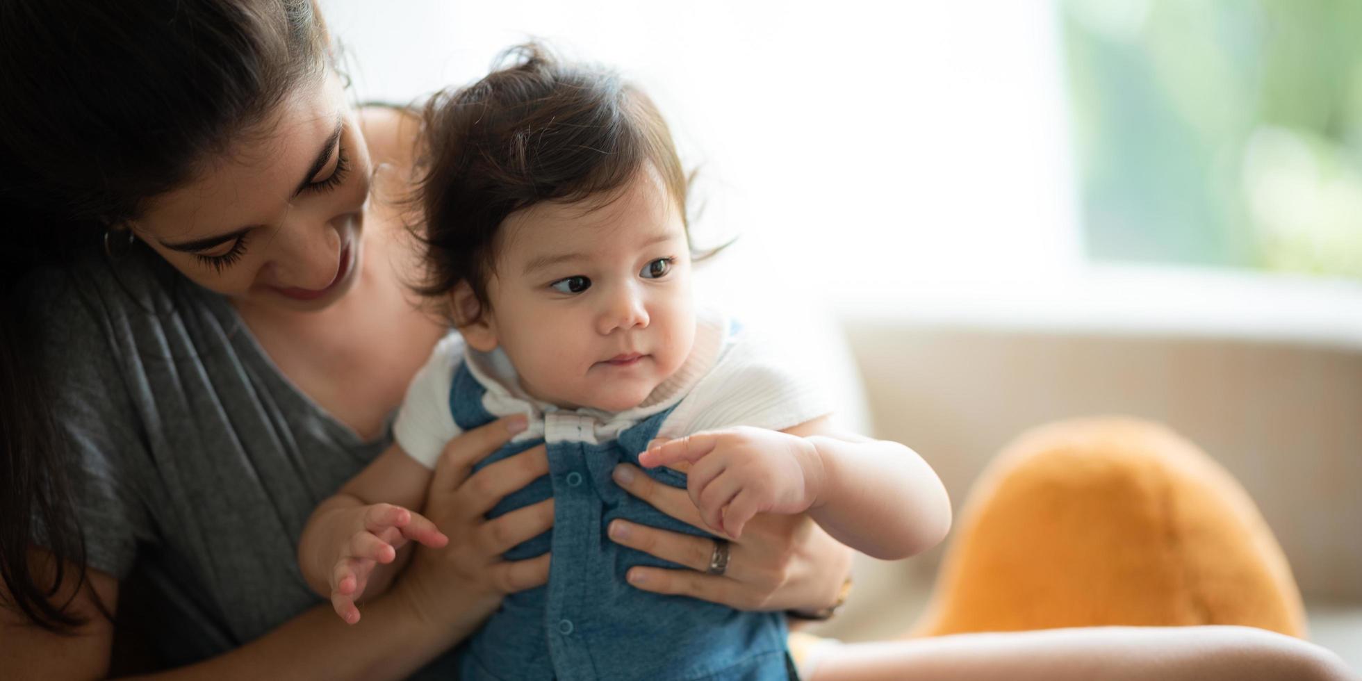 madre joven y bebé son felices en casa, concepto de familia infantil con madre caucásica y niño pequeño, estilo de vida de cuidado de recién nacidos foto