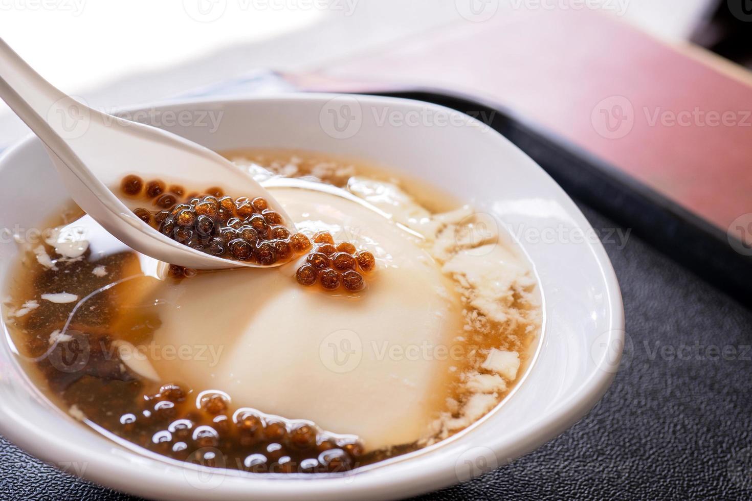 Popular Taiwan gourmet - Dessert of tapioca pearl ball bubble mixed bean curd tofu pudding douhua, dou hua in white bowl, close up, lifestyle photo