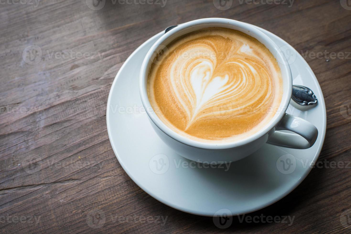 una taza de café con leche caliente con latte art en la superficie. latte es una bebida a base de café hecha principalmente de espresso y leche al vapor. foto