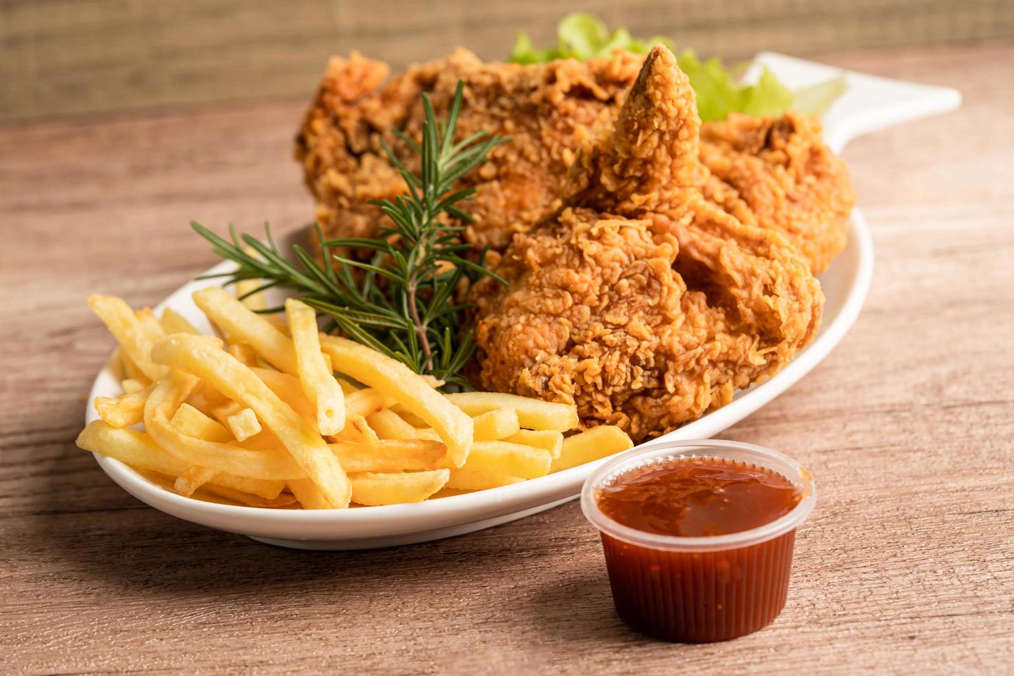 Fried chicken and potato chip with rosemary leaf, Junk food high calorie served on white plate photo