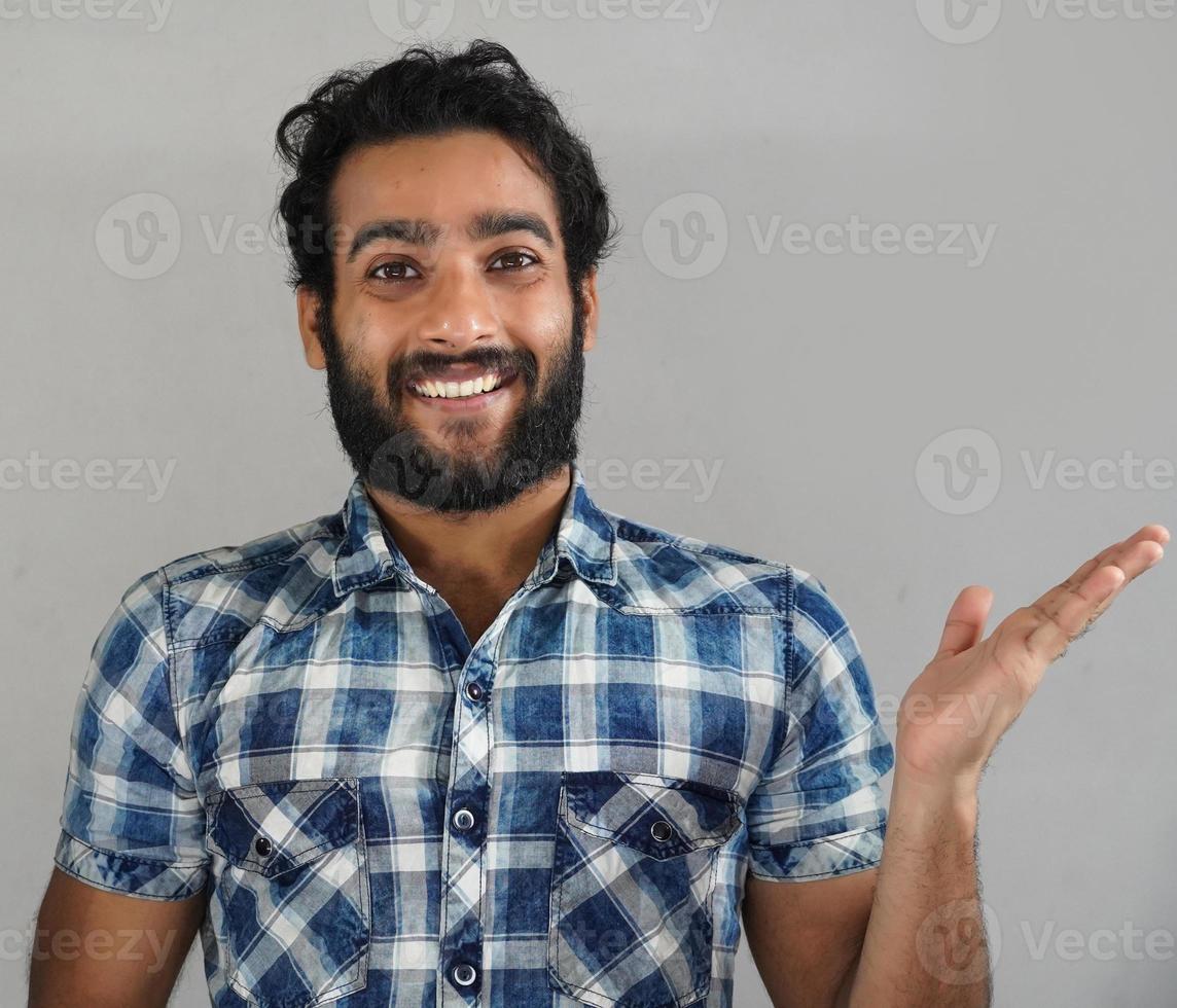 joven mostrando algo en el lado derecho usando la mano foto