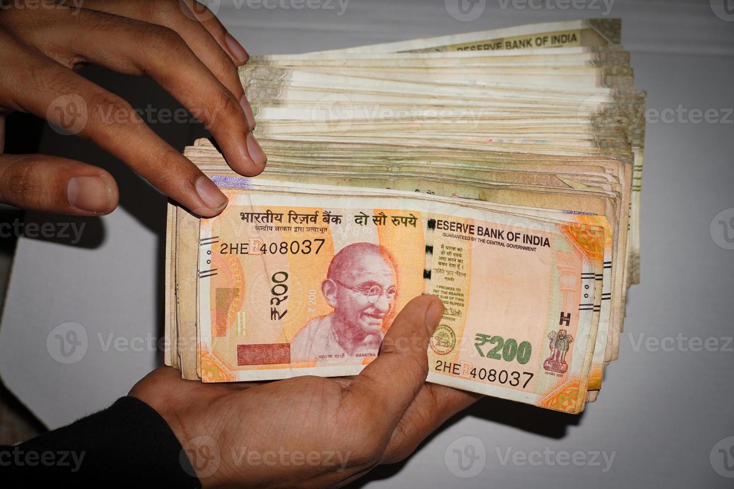 imágenes de moneda india en billetes de mano de 200 rs y billetes de 500 rs foto