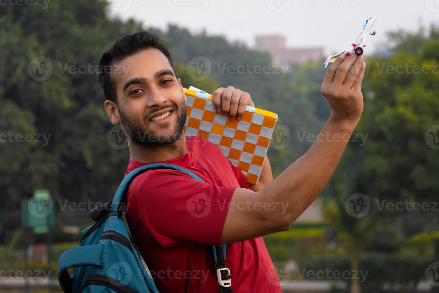 Indian man having bag book and aeroplane photo