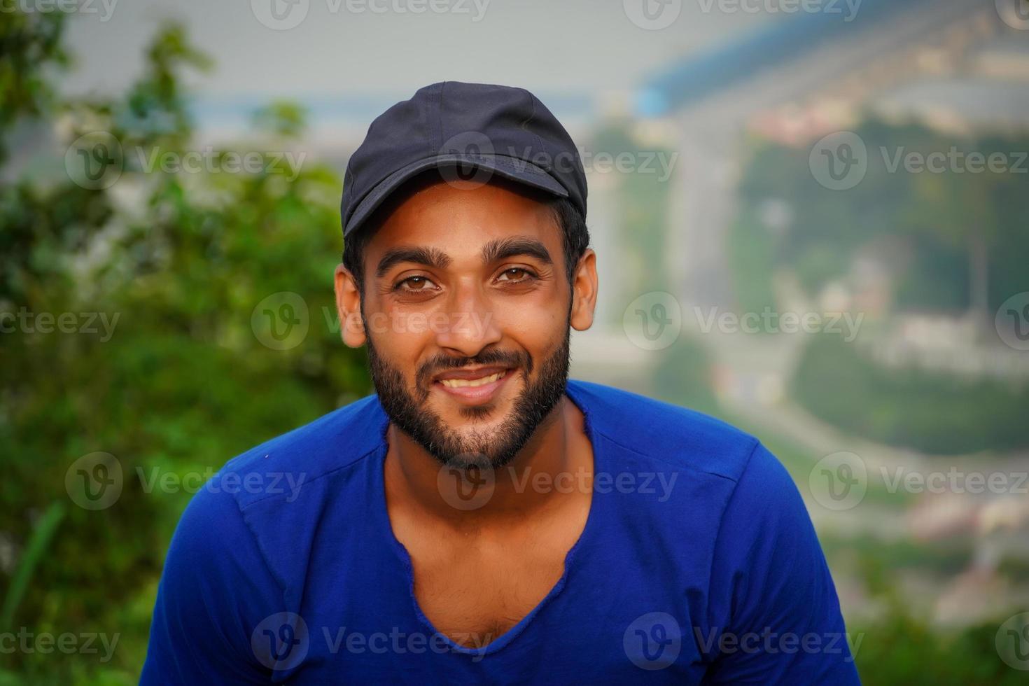 a young man looking at the camera and smiling photo