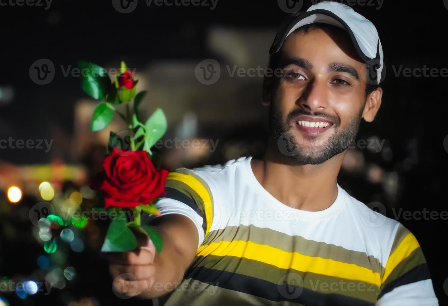 boy giving rose to his lover - red rose in hand photo