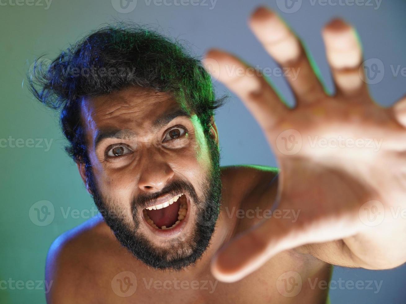 young man angry face indicating hand to you studio shot photo