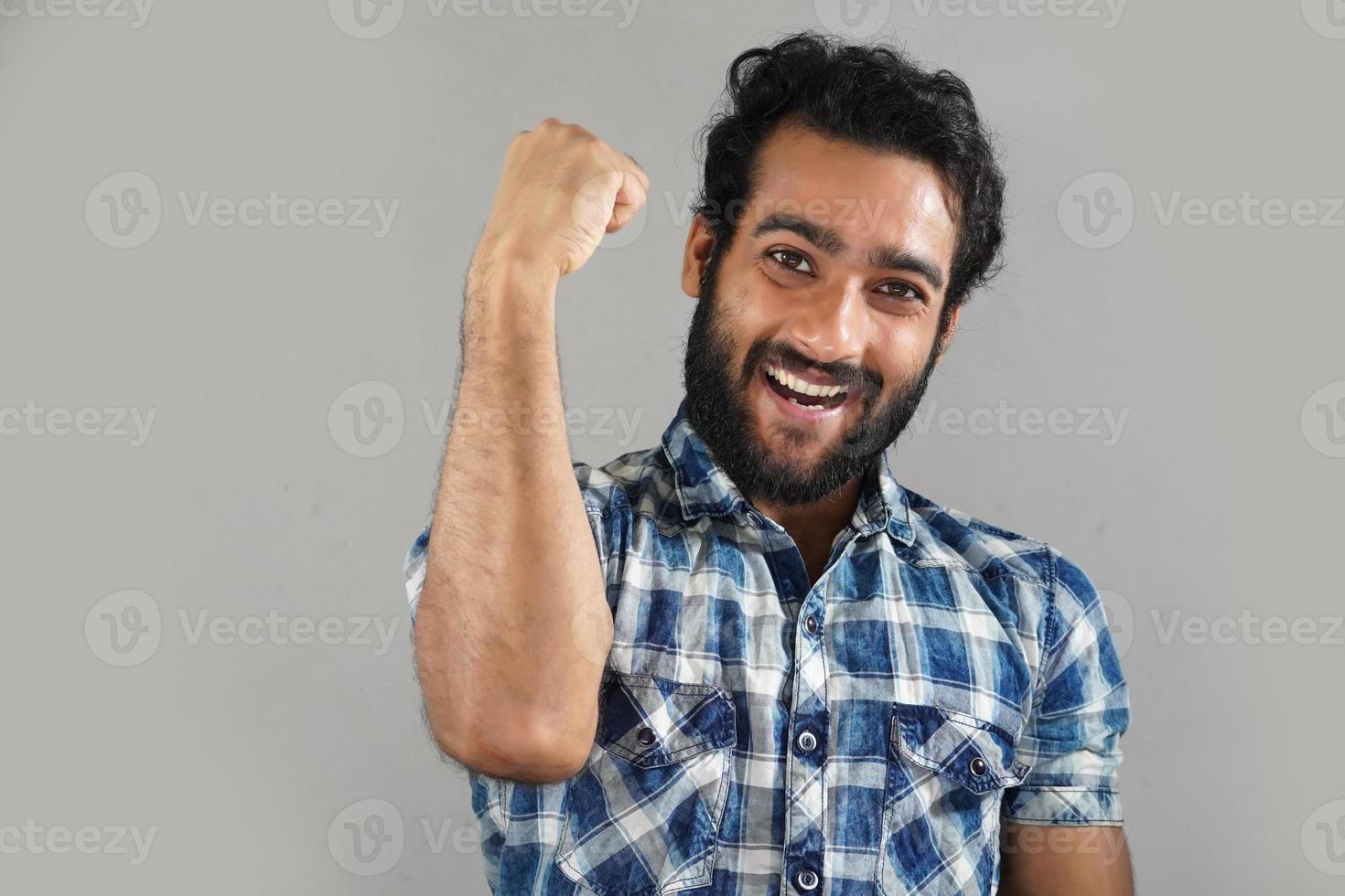 Close up of successful young male man screaming yes and raising clenched fists in the air, feeling excited. people, success, triumph, victory, winning and celebration photo