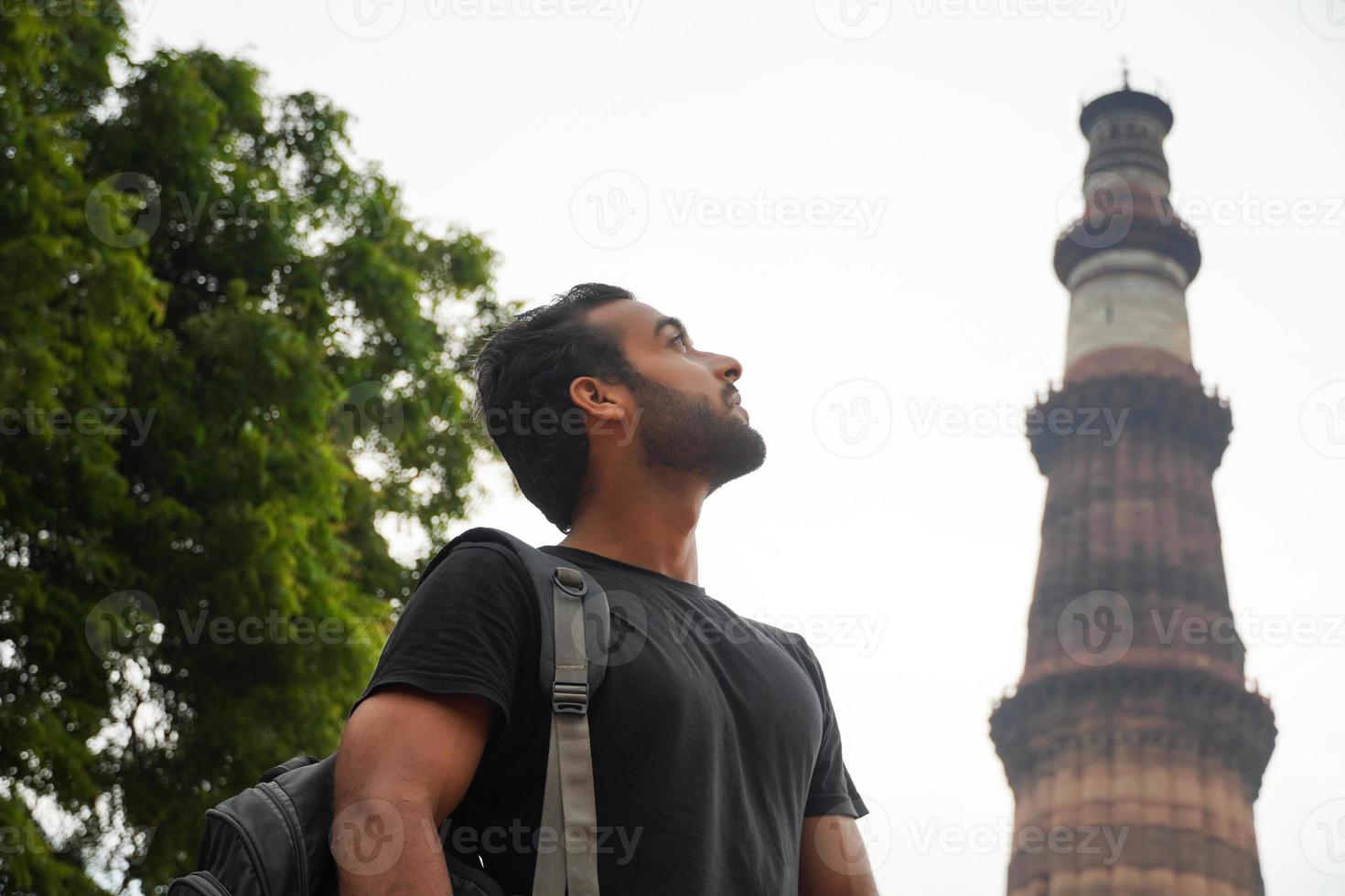 indian young handsome man at historical palace qutub minar travel in india image photo