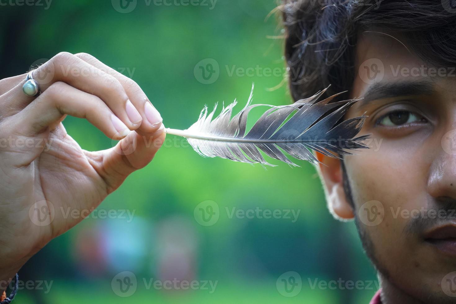 a boy withe feather playing with feather photo