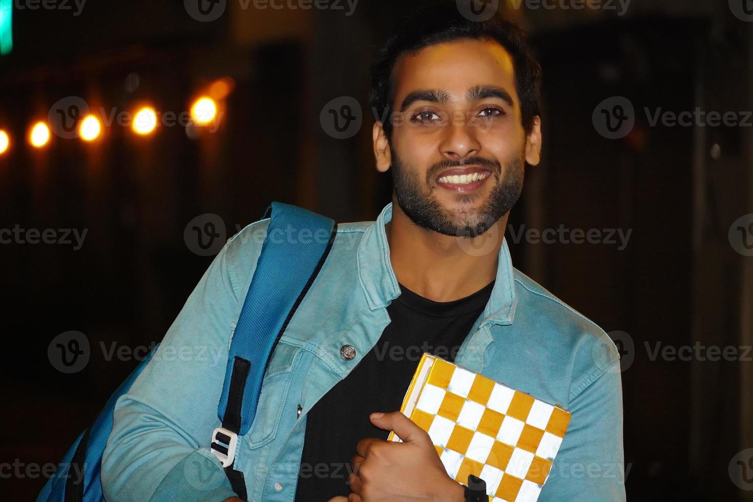 joven estudiante con libro y bolso en la noche foto