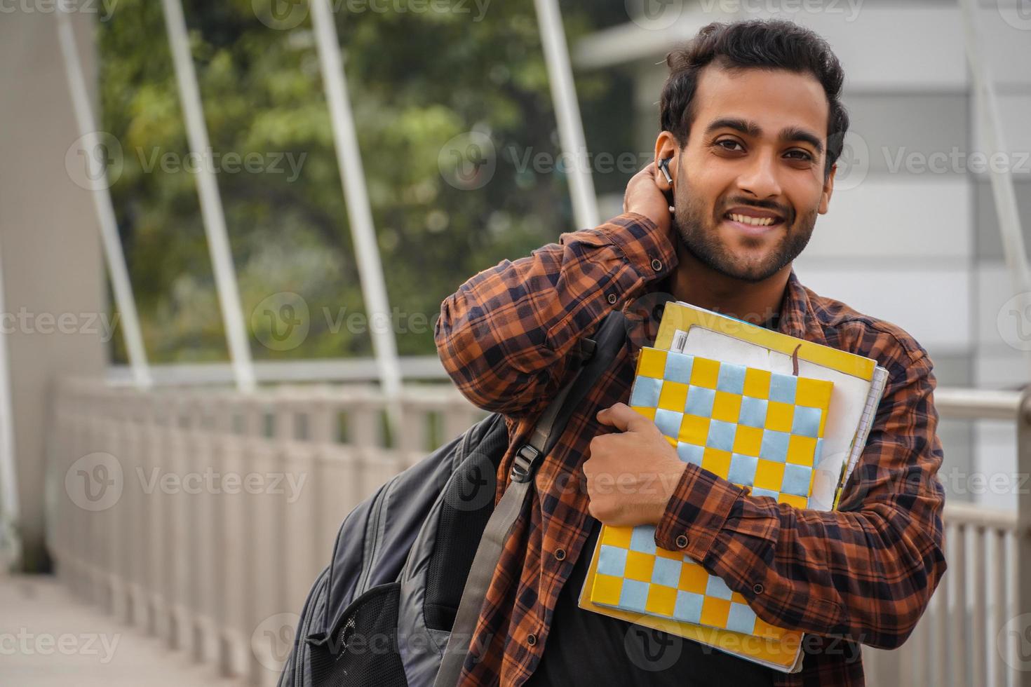 A confused boy smiling in camera and going for college photo