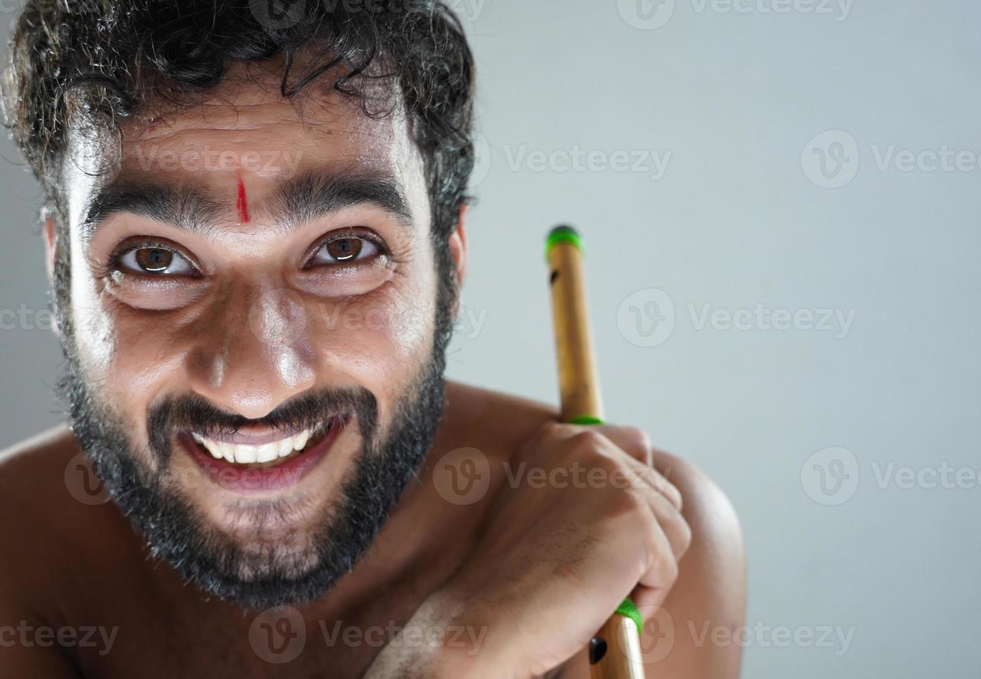 hombre hindú indio con flauta y cara feliz foto