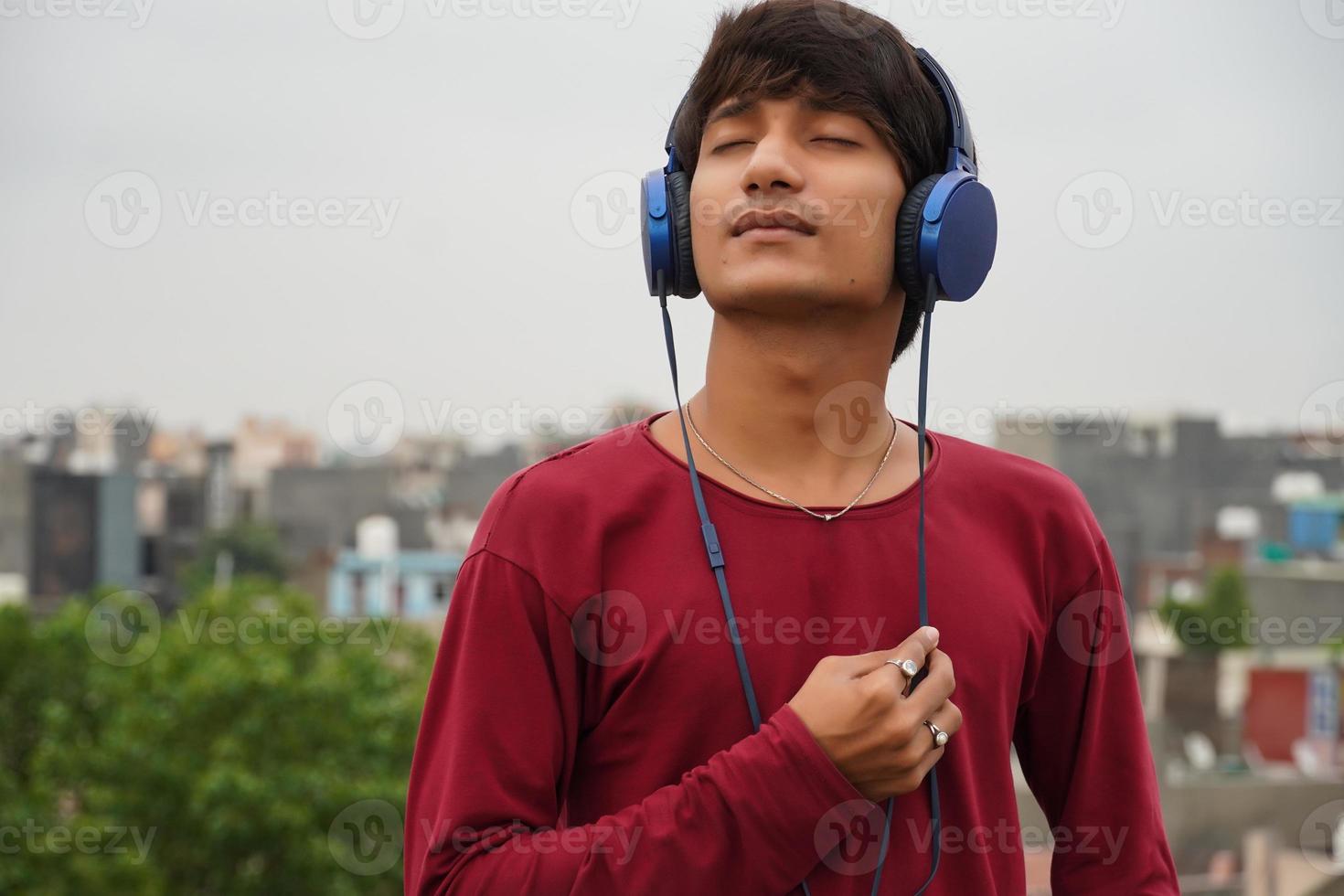 hombre asiático con auriculares escuchando música foto