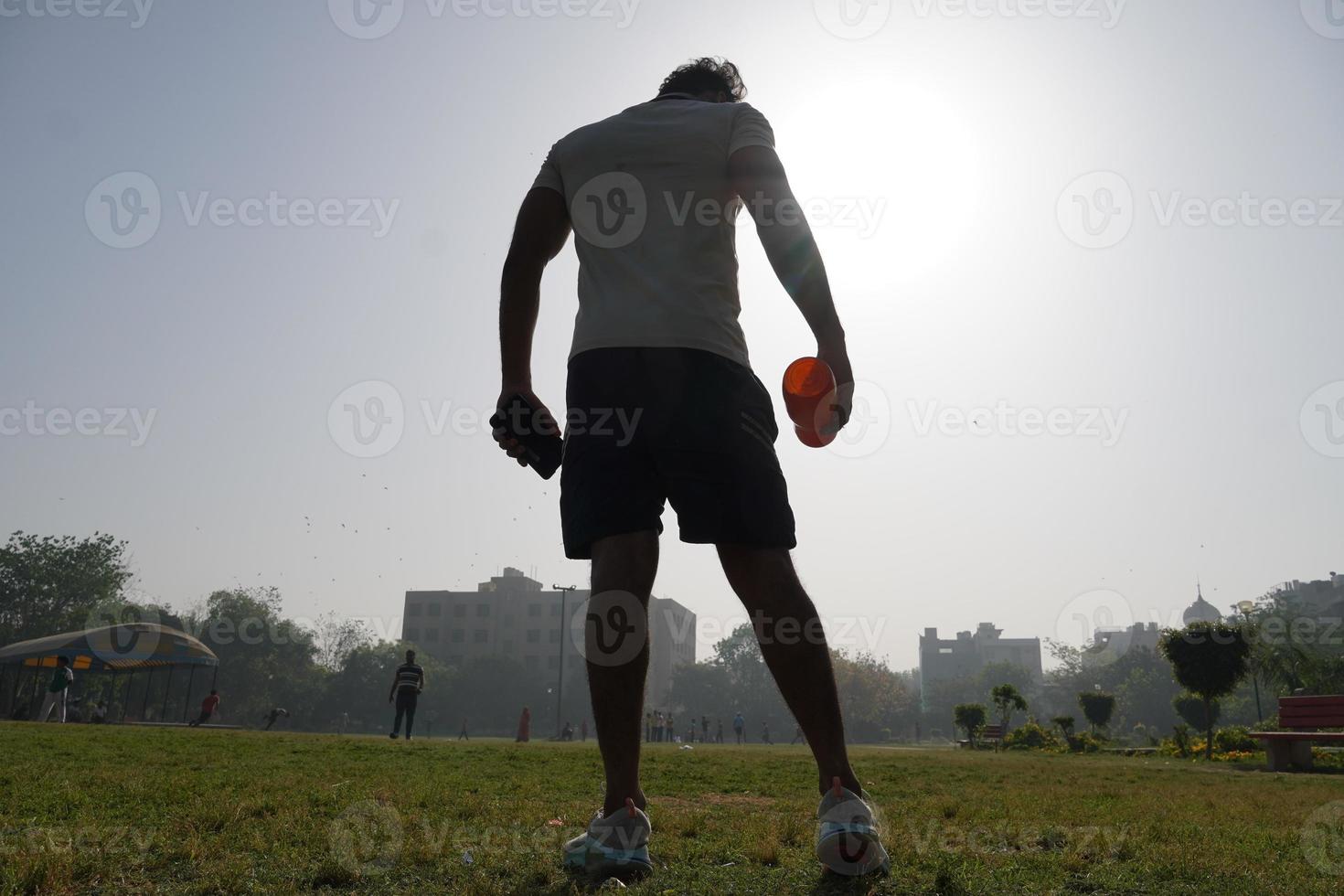 man at stedium over the silhouette image with shaker bottle for gym and drinking gainer -physical fitness concept photo