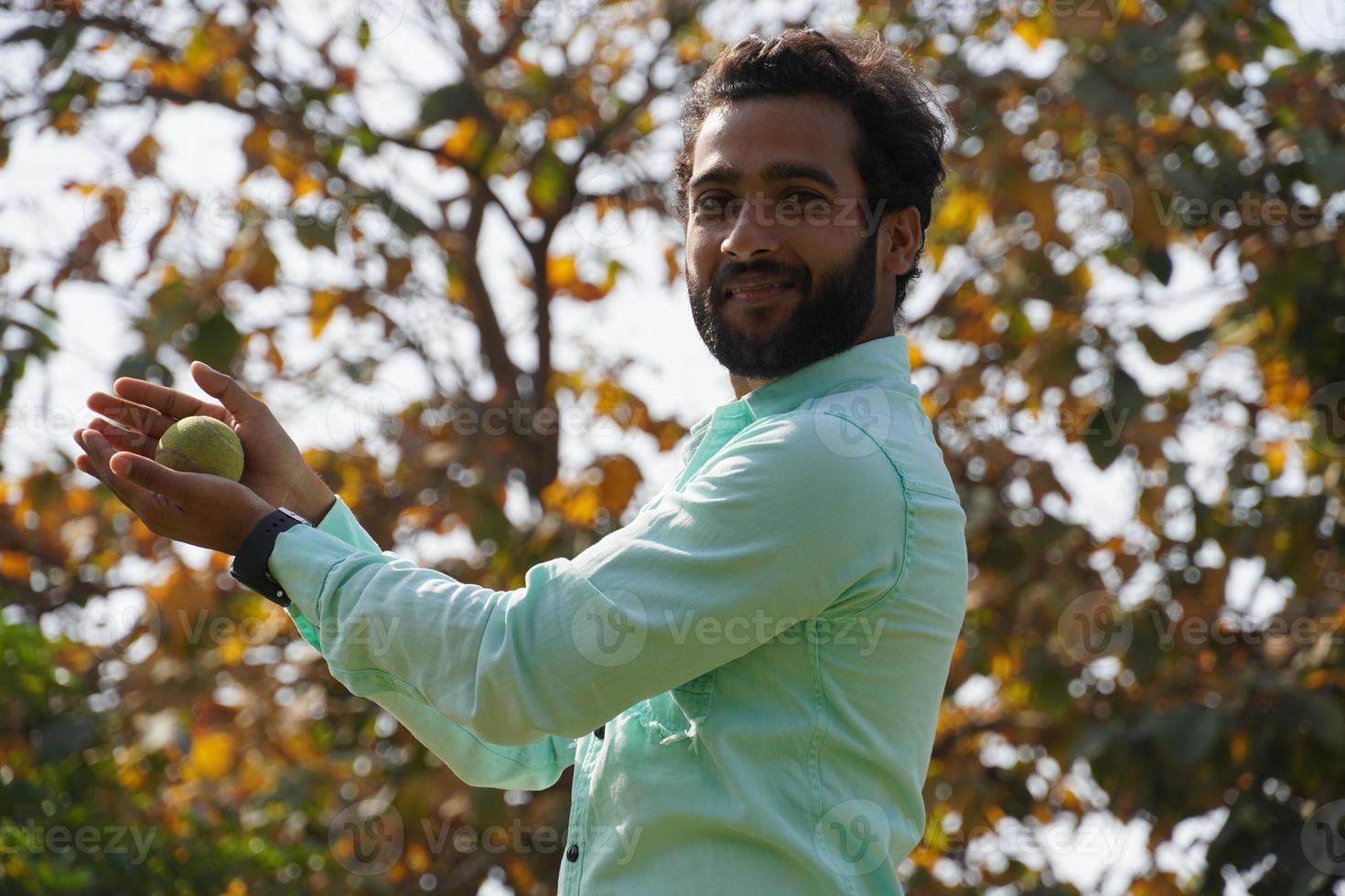 man in action of catching ball in cricket match photo