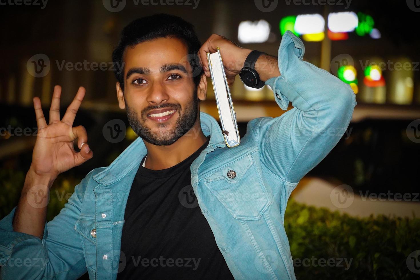 A young college student having book and giving review this is the best book photo