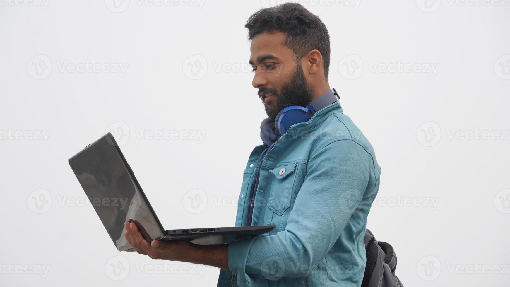 un joven estudiante con computadora portátil y concepto de educación de auriculares foto