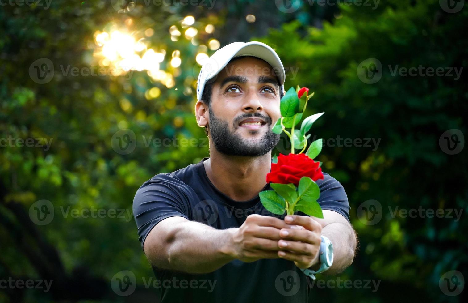 proposing to his Girlfriend man with beautiful red rose giving to girl photo