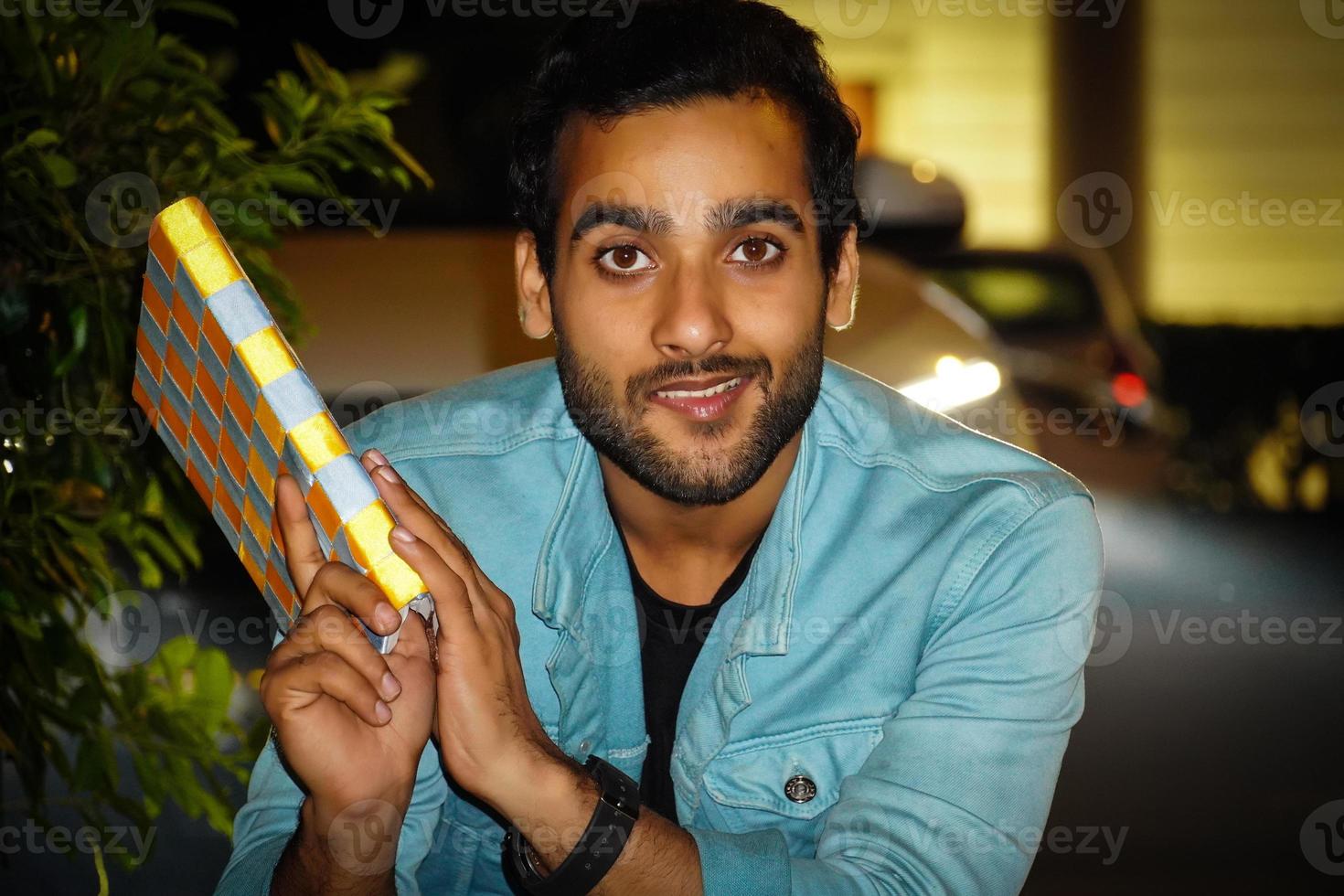 A young man having book watching camera and giving a smile photo