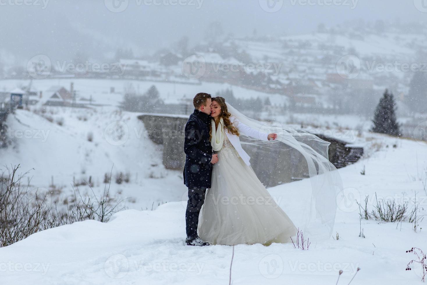 el novio lleva a su novia de la mano a una vieja y solitaria haya. boda de invierno. lugar para un logotipo. foto