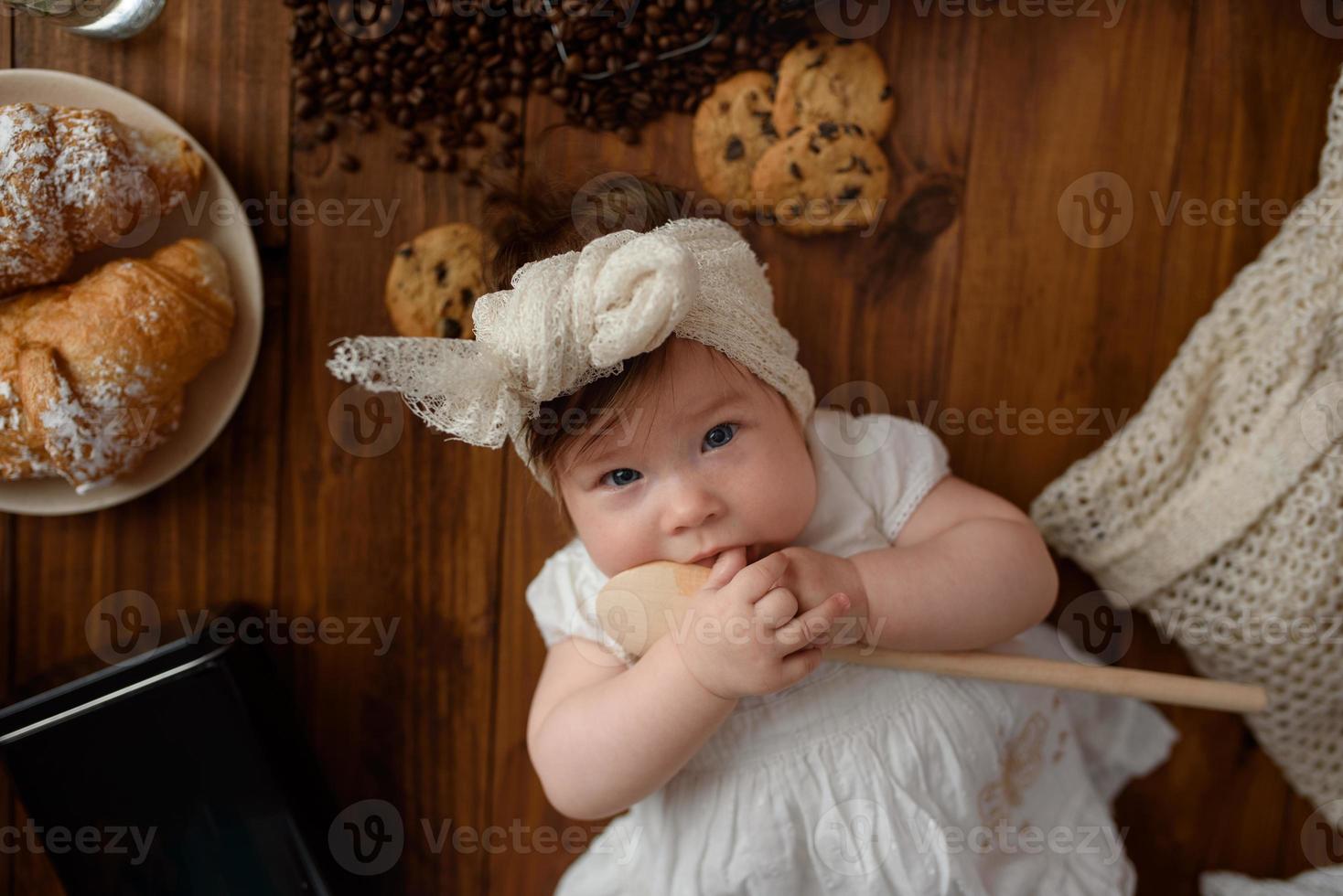 Little girl cook with a wooden spoon is preparing lunch. photo