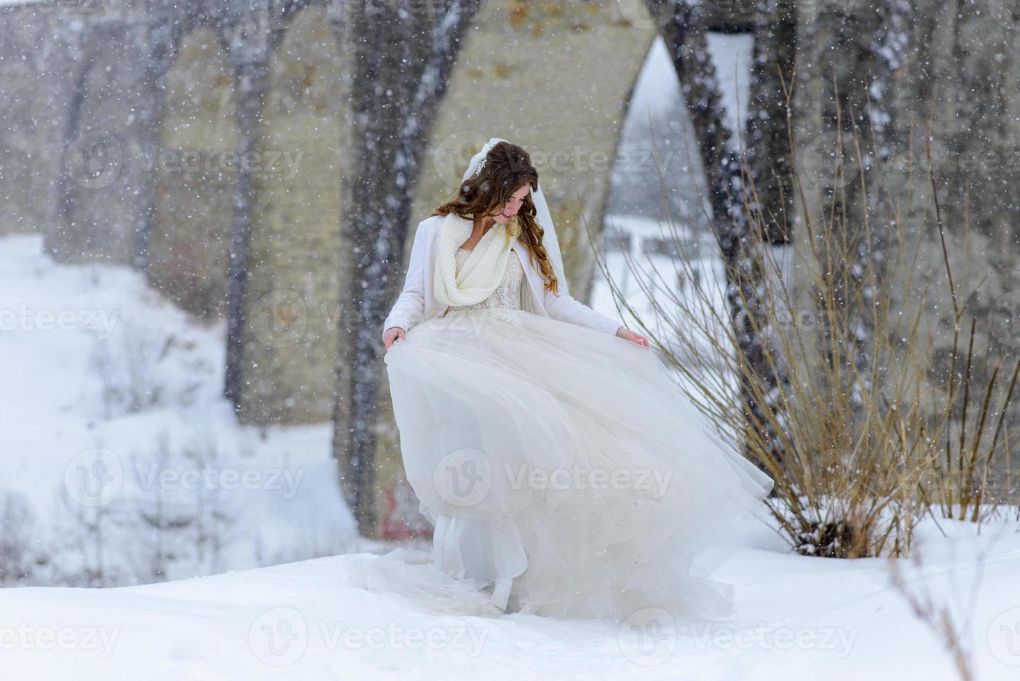 The groom leads his bride by the hand to a lonely old beech. Winter wedding. Place for a logo. photo